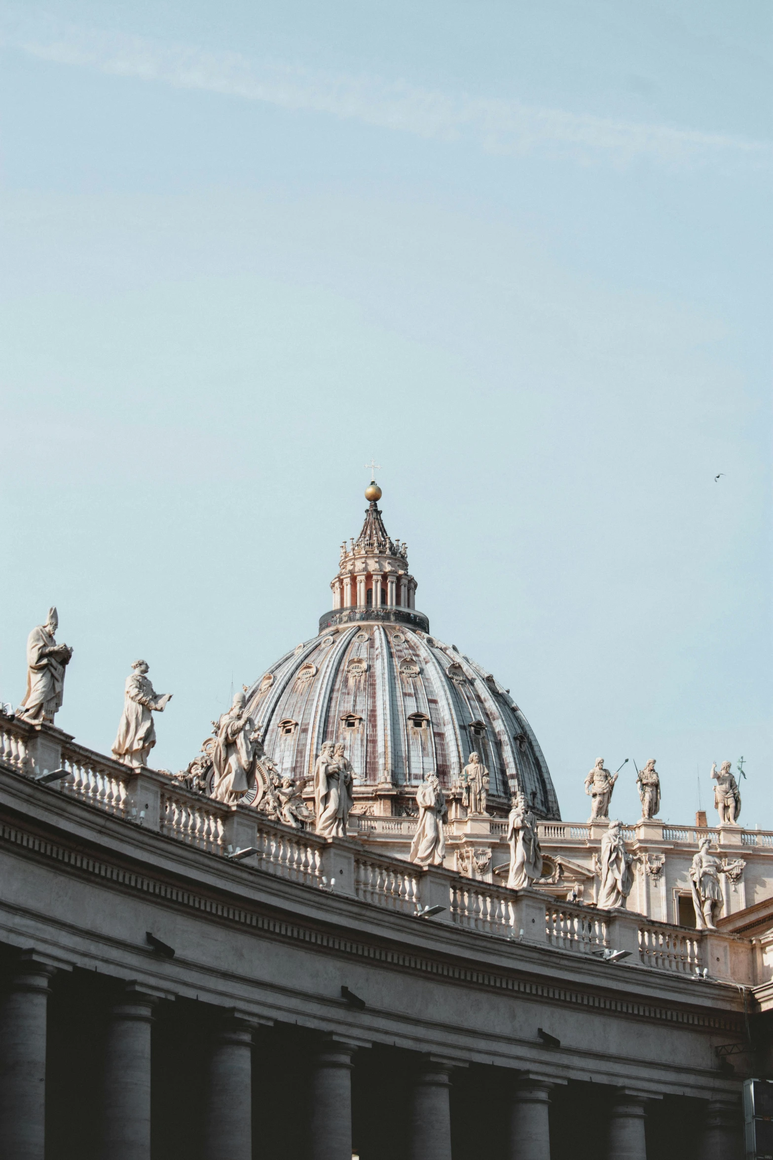 the dome of a church that is surrounded by statues