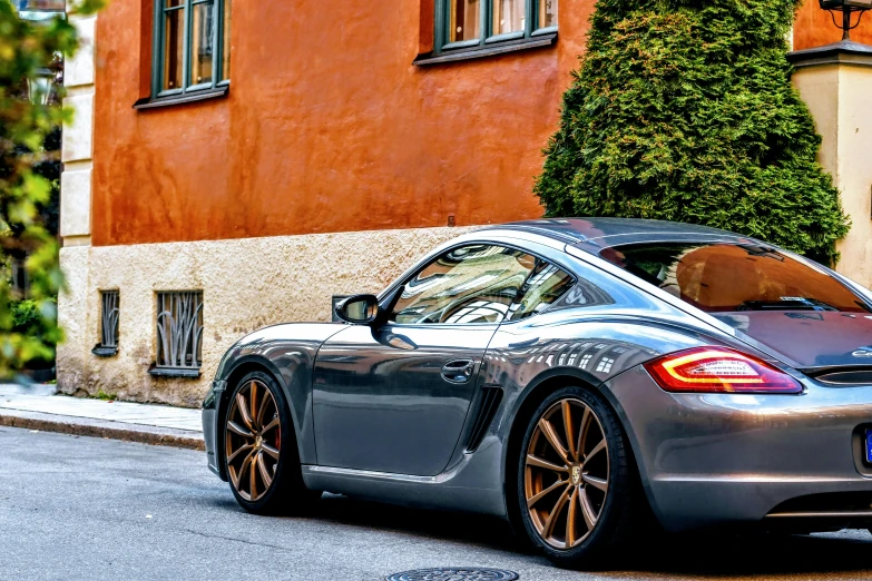 a grey and orange sports car sitting on the street