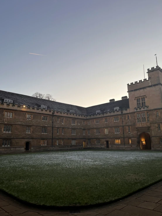 a very large building that has a big grassy field