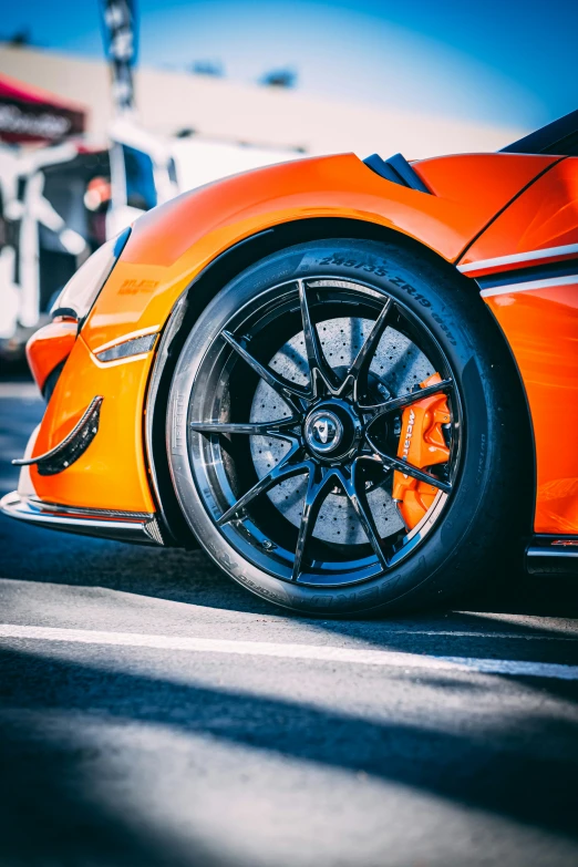 an orange sports car is parked on a parking lot