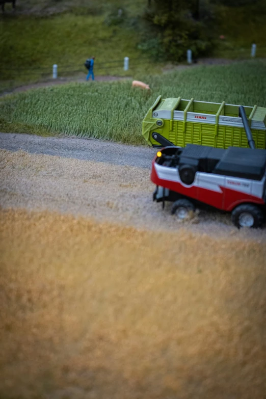 a small red cart on the street near a grass area