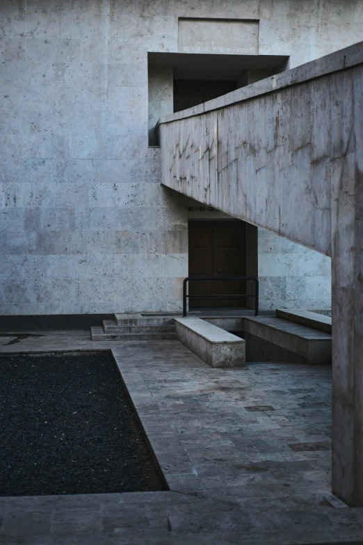 a concrete stair case with benches and a ramp leading to a door