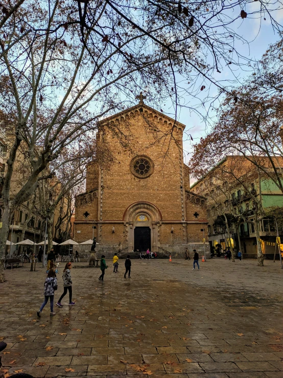 a large brick church with two towers sitting between buildings