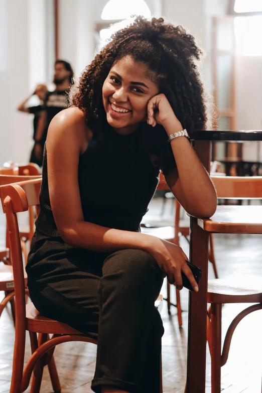 a smiling woman sitting on a bench near a table