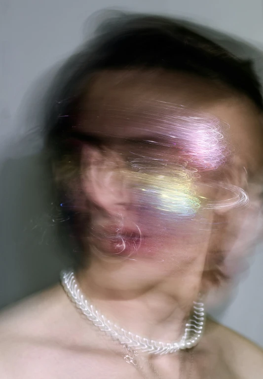blurry image of woman wearing pearl necklace and pearls