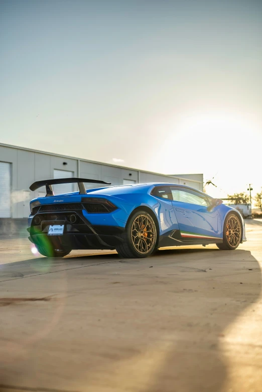 a blue lambino with black wheels parked outside of a building