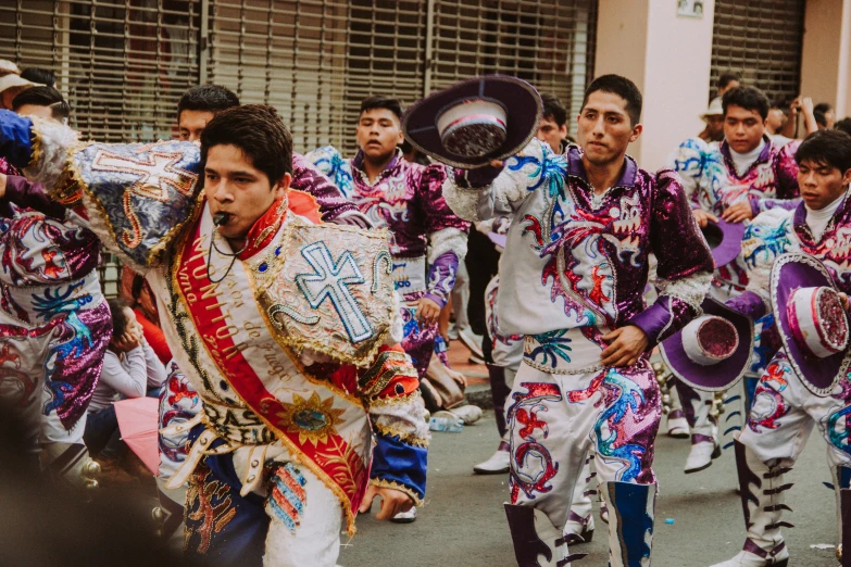 a band of people walking down a street with colorful costumes