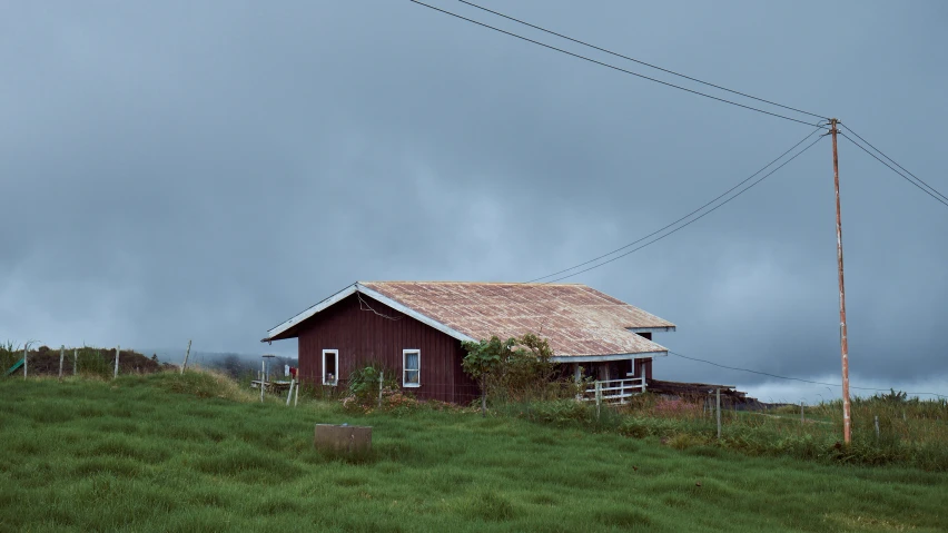 a house on top of a hill on a cloudy day