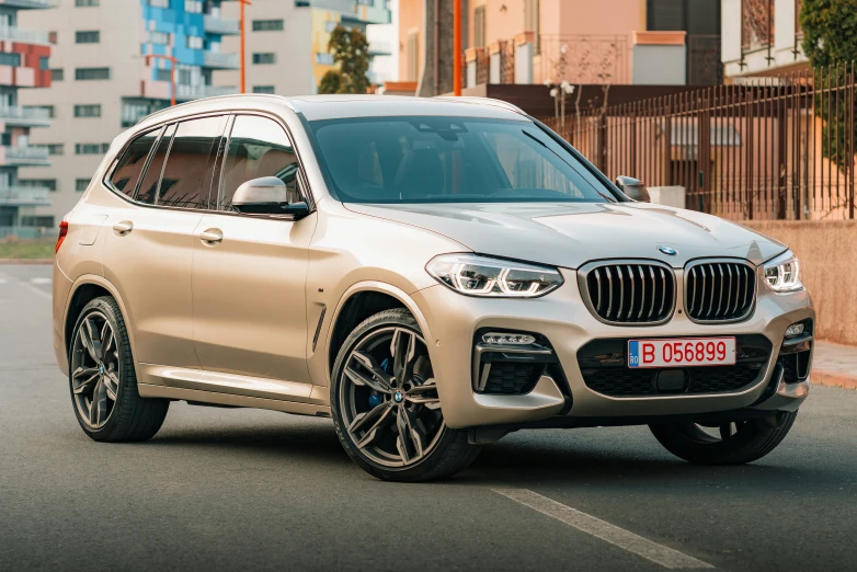the 2019 bmw x4 is driving down a street in an urban setting