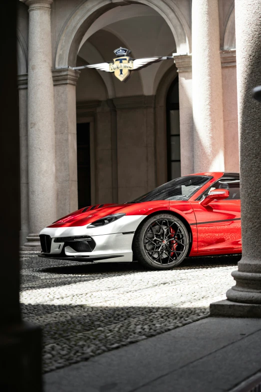 a red and silver sports car parked in a courtyard