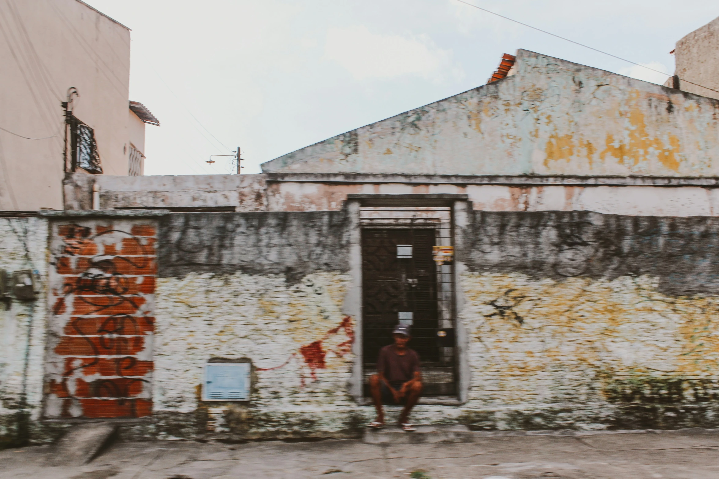 a man stands in front of a doorway on a street