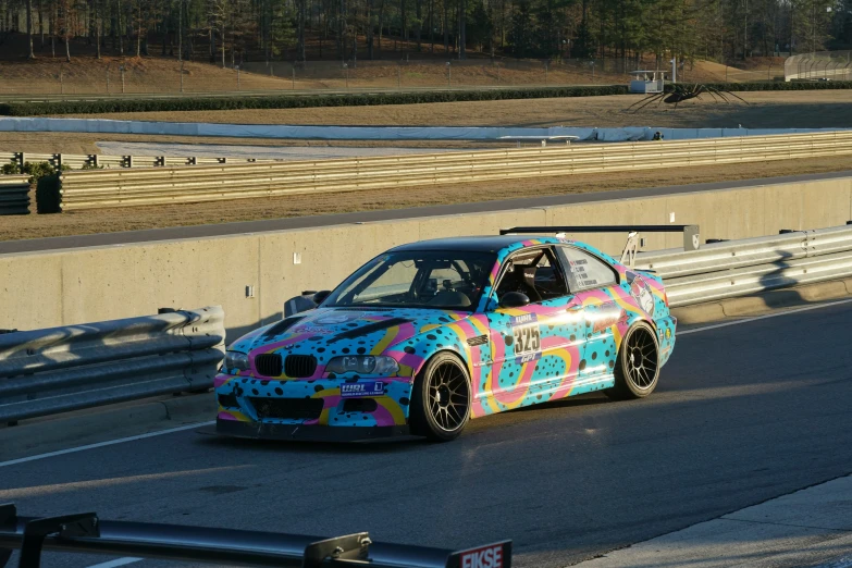 a multicolored car driving along the street