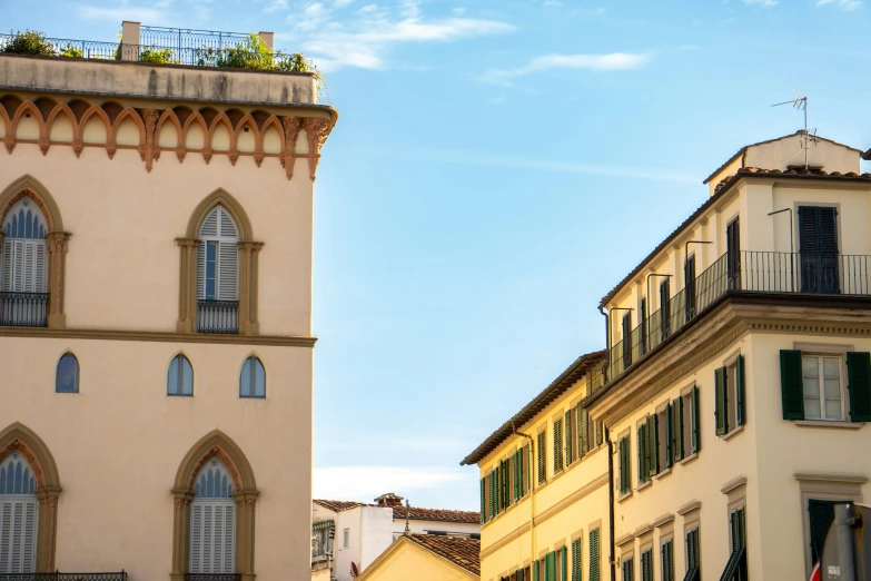 two buildings near one another with small balconies on the roof