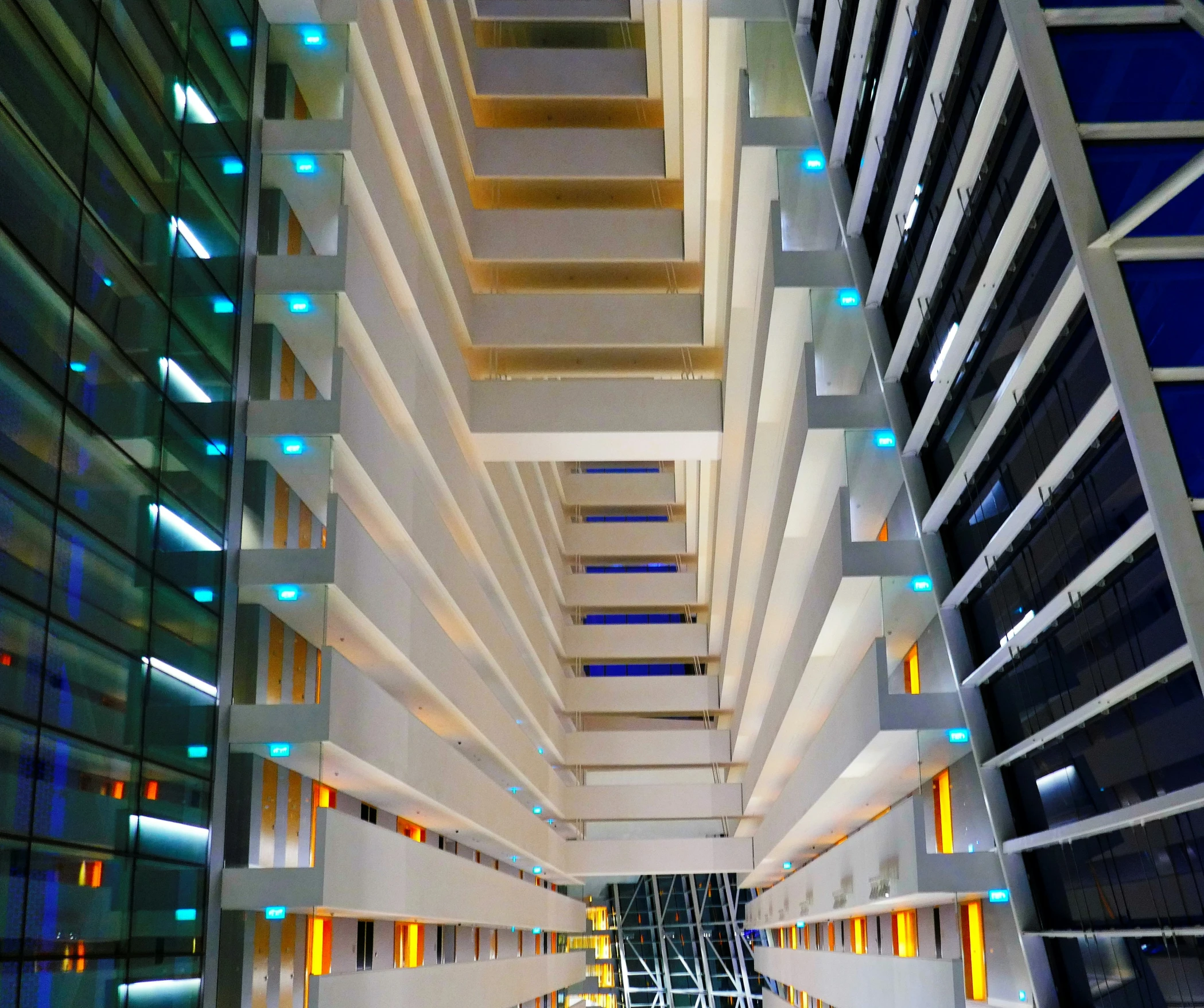 an atrium with glass panels, lights and sculptures