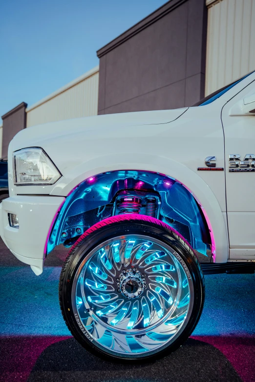 a bright white truck with a pink and blue light up tire