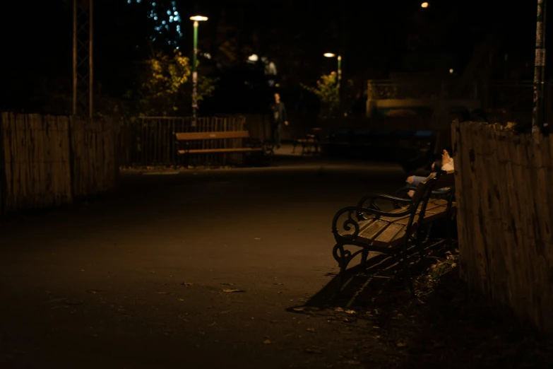 a bench is in the street and there are lights on