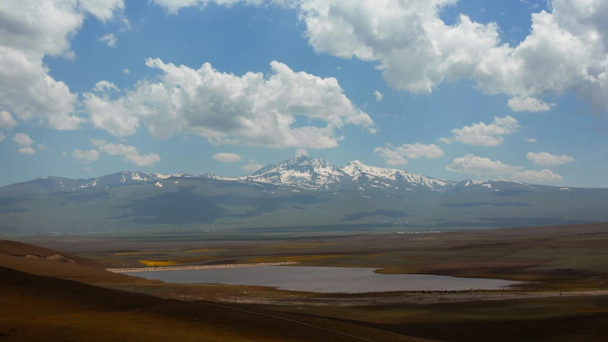 the snow - capped mountains are shown over a lake