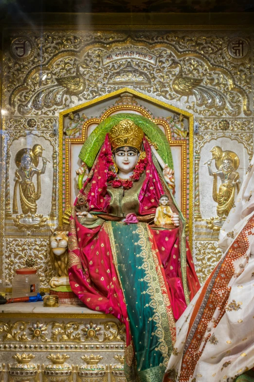 a shrine statue sitting on top of a table in front of a mirror