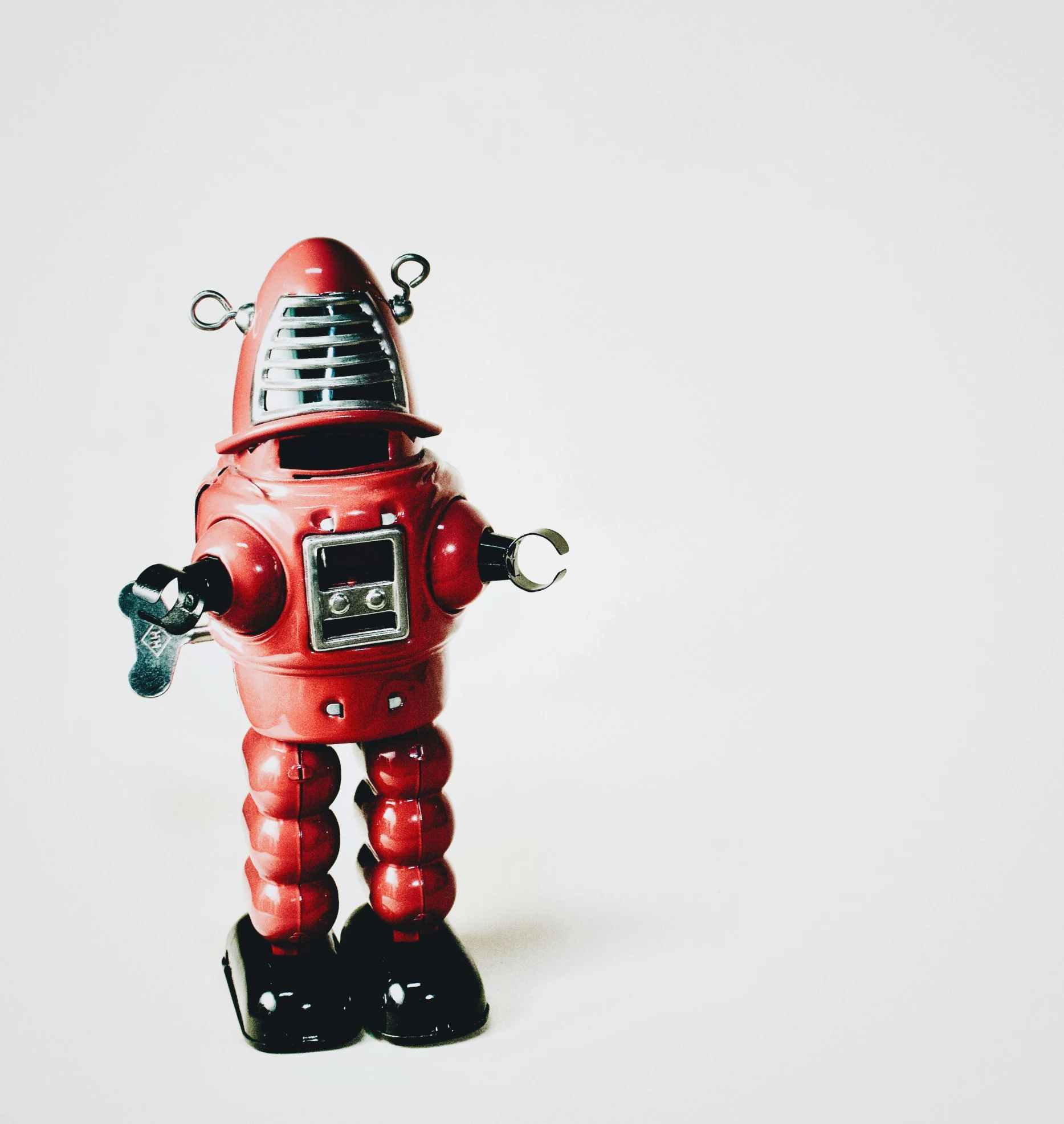 a red toy robot holding a microphone up to its ear