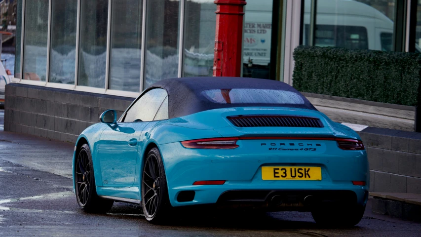 the blue porsche 990 is parked on the side of the street