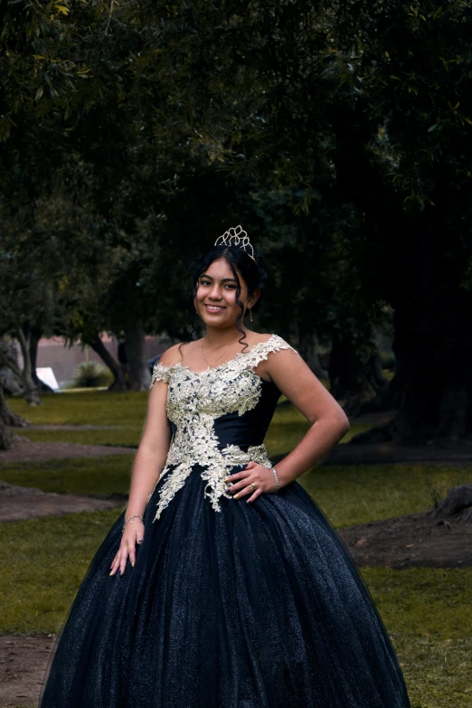 a woman in a long dress stands in the grass