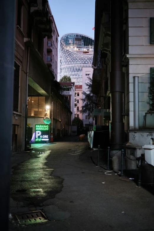 a street is lit up as the light of buildings shine brightly