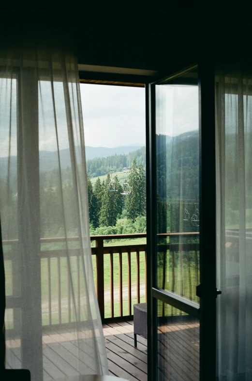 the open doors of a deck in a porch looking out onto a wooded valley