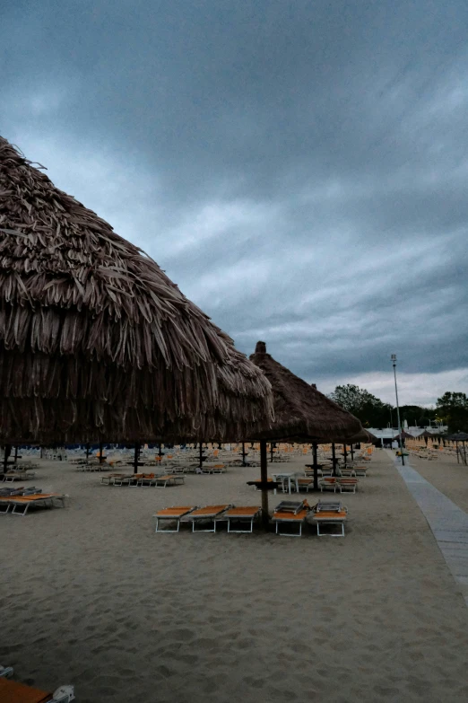 a view of a beach in the evening with umbrellas