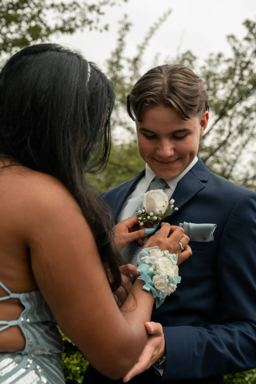 a man adjusting a flower on his brides suit