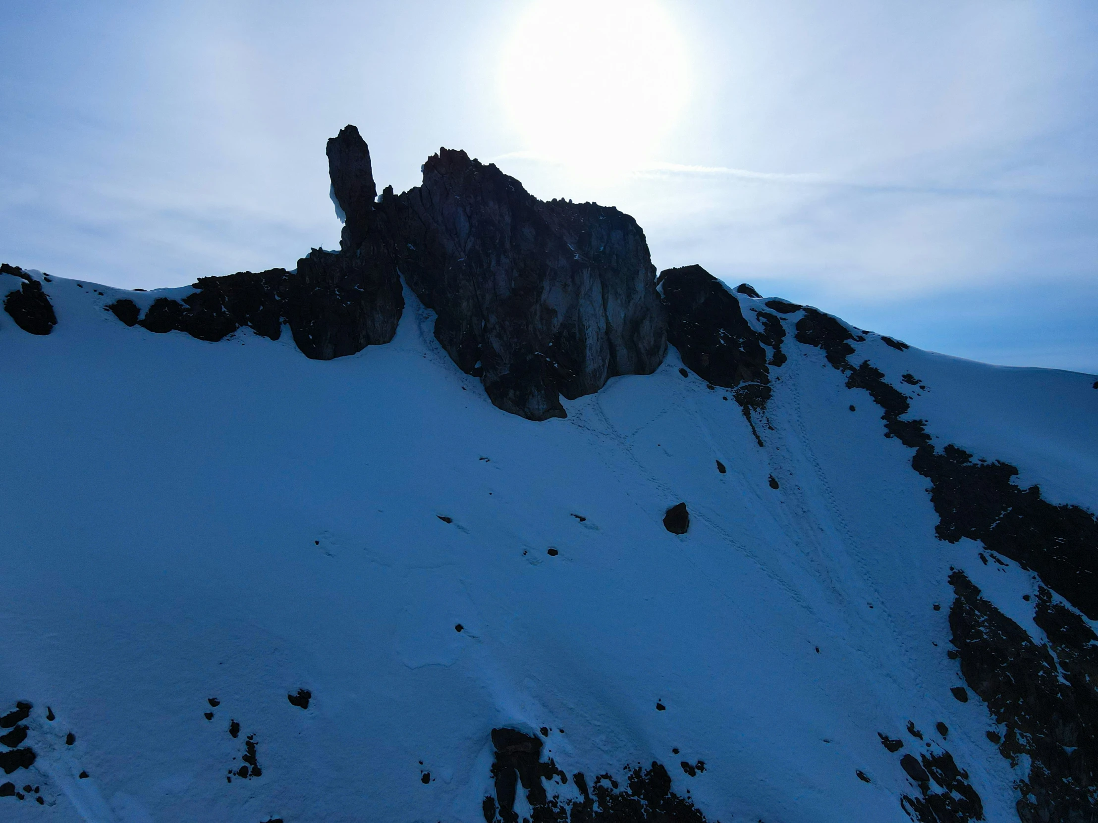 snowboarder heading down the side of a large mountain