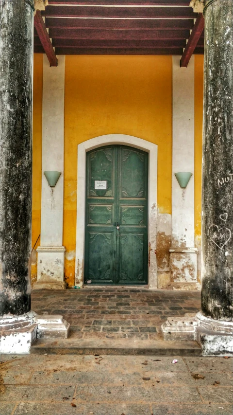 a green and white building with pillars on either side