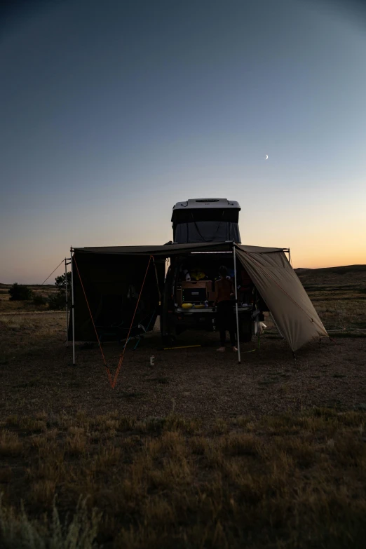 a truck parked in the field near an awning