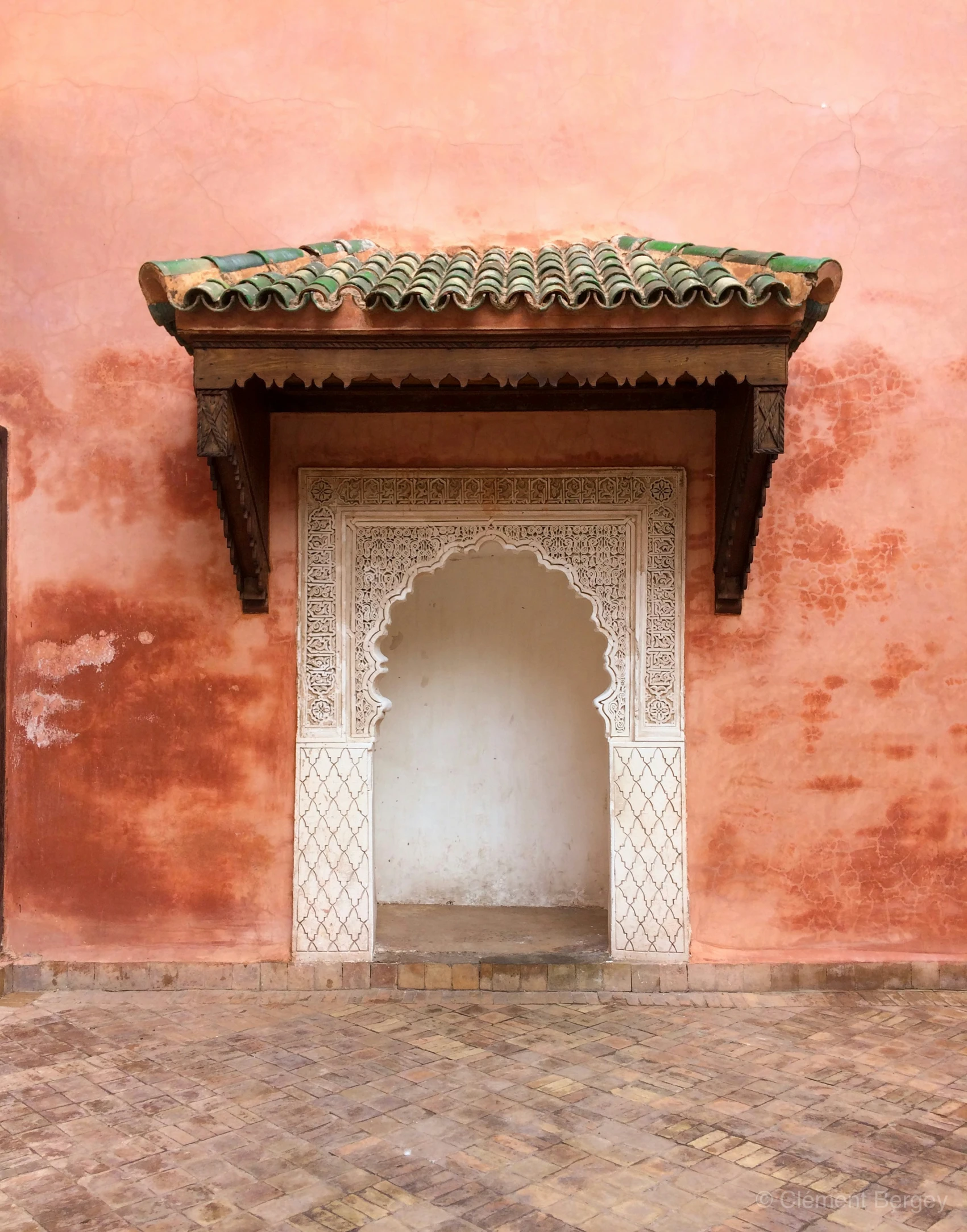 a pink building with tile roof on the sides