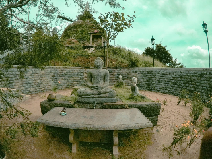 a statue of buddha sitting on a stone structure