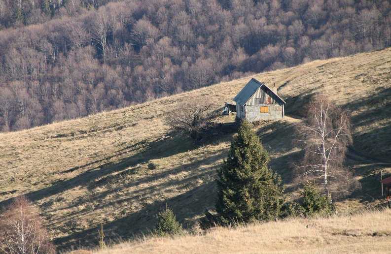 an abandoned house on the side of a mountain