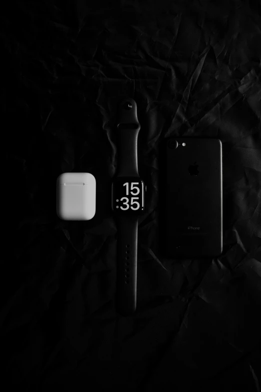 two apple watch faces sitting next to an iwatch in black and white