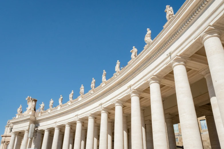 a building with white columns and statues near the front