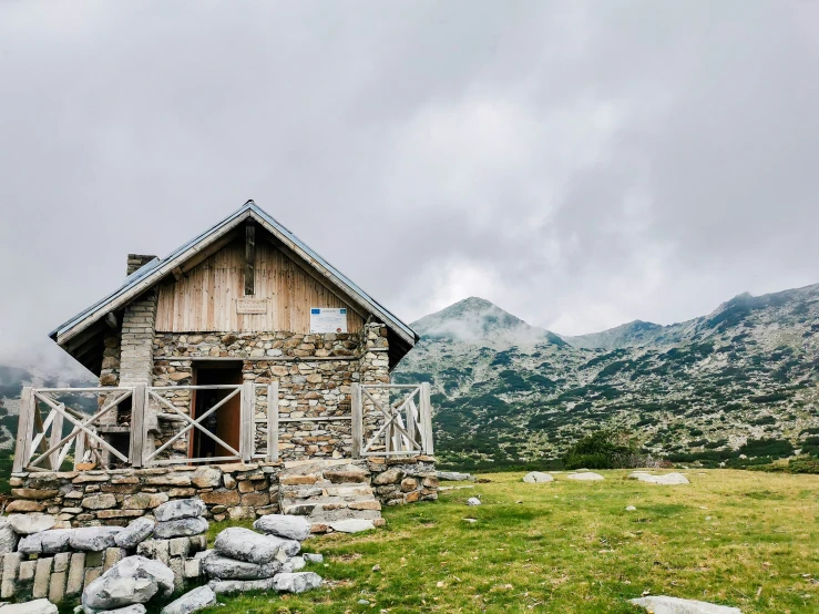 the small house is built on rocks in a field