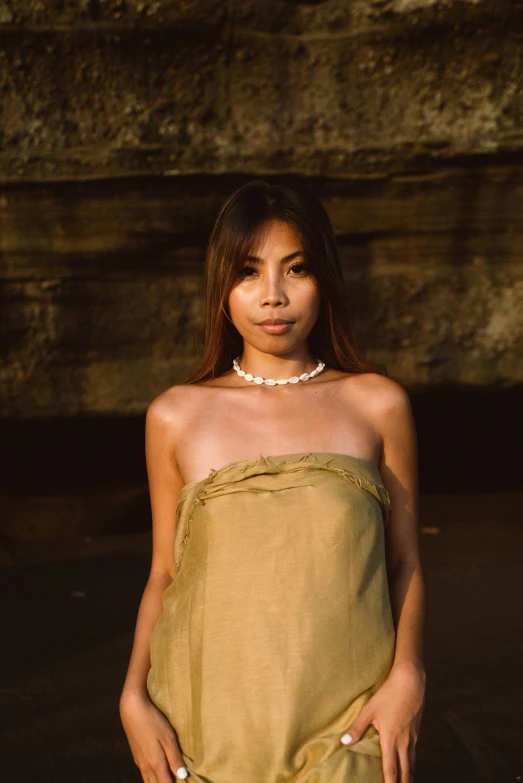 a woman in a tan towel wearing pearls