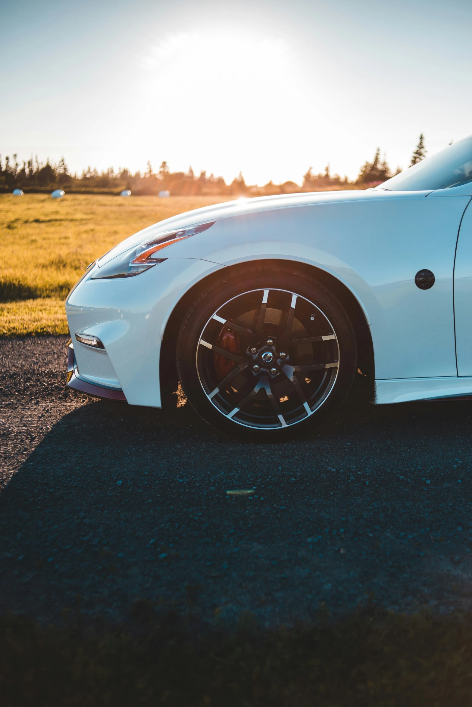 a white sports car sits in the road