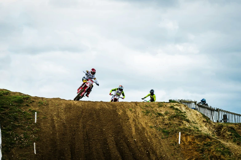 two dirt bike racers on their bikes going off the hill