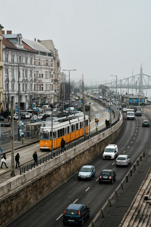 a train on the tracks and cars driving down the road