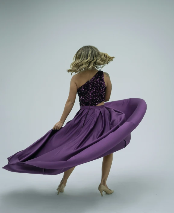 a woman in a purple dress dancing