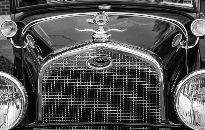 the front of a vintage automobile with the hood and grille grilles on