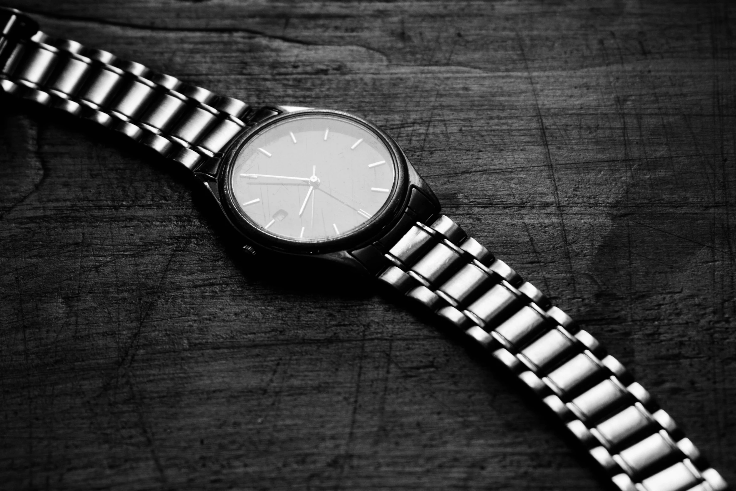 a white watch is seen sitting on a wood surface