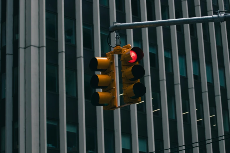 a traffic light with yellow lights standing beside a building
