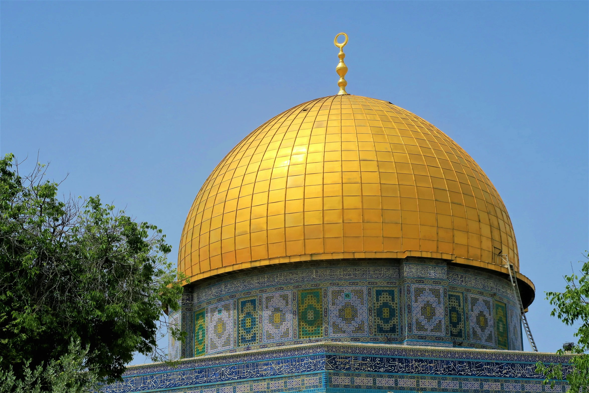 the top of a dome with gold and blue tiles