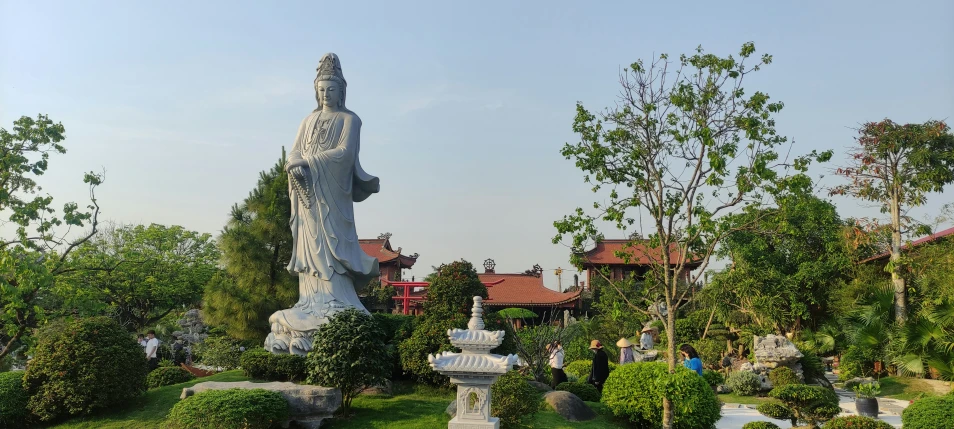 a statue stands in the middle of some greenery