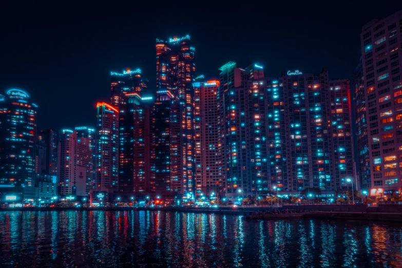 a lit up city by the water at night