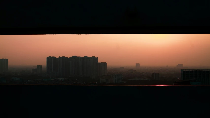 a city skyline seen through a window in a dark room